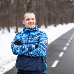 Sporty man runner looking on side and smiling