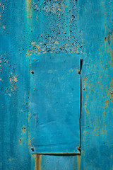 Rusty iron wall covered by old blue paint. Abstract background.