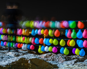 colourful balloons on the rocks during night time, vibrant colours, abstract cityskape 