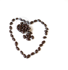 Nuts arranged in heart shape on background. Food image close up candy, chocolate milk, extra dark almond nuts. Love Texture on white grey table top view