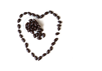 Nuts arranged in heart shape on background. Food image close up candy, chocolate milk, extra dark almond nuts. Love Texture on white grey table top view