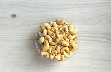 Healthy food  for background image close up cashew nuts.  Nuts texture on white grey table top view on the cup plate