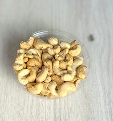 Healthy food  for background image close up cashew nuts.  Nuts texture on white grey table top view on the cup plate