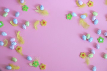Kolorowe jajka, kwiatki i piórka na różowym tle, motyw wielkanocny - obrazy, fototapety, plakaty