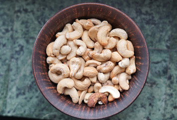 Healthy food  for background image close up cashew nuts.  Nuts texture on white grey table top view on the cup plate