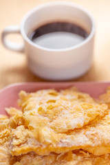 Food and dessert. Crackled crispy cookies with sugar on a plate and a cup of coffee on a wooden table. Blurry background and soft focus. Close-up.