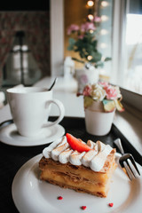 Millefeuille Napoleon with coffee in cafe. Exquisite dessert with fresh berries on white background. French Vanilla Raspberry Mille-feuille on the dish