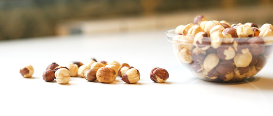 Healthy food  for background image close up hazelnuts.  Nuts texture on white grey table top view on the cup plate