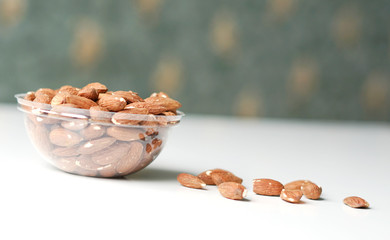 Healthy food  for background image close up almond nuts. Texture on white grey table top view. Nuts on the cup plate