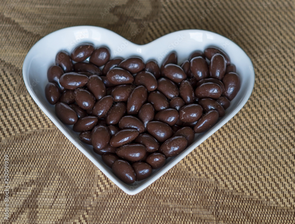 Wall mural nuts arranged in heart shape on background. food image close up candy, chocolate milk, extra dark al