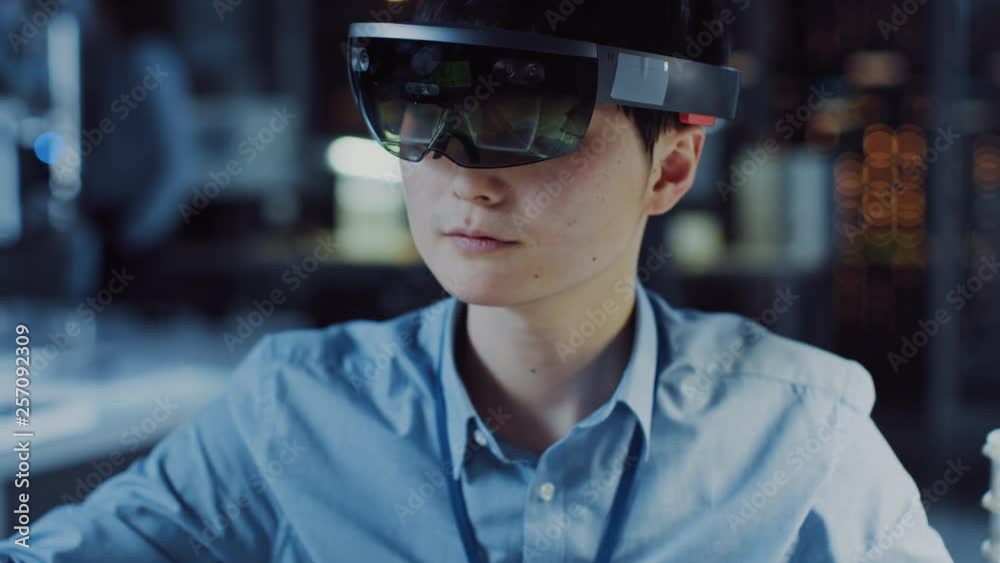 Poster professional japanese electronics development engineer in blue shirt is wearing a virtual reality he