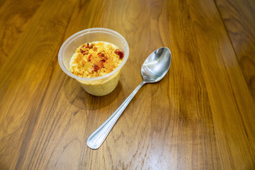 Spoon with granola in a plastic cup
