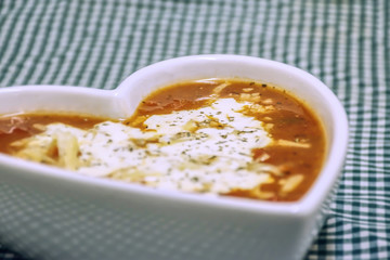 Tomato and cheese soup in heart shaped bowl.