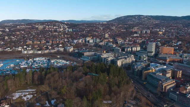 Aerial POI clockwise time lapse city and traffic on e18 highway footage near Skoyen urban area in Oslo, Norway at sunrise in spring 2019