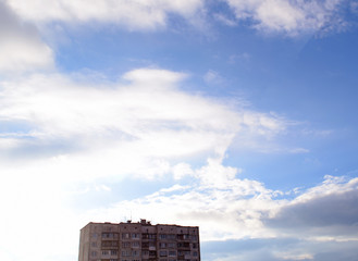 View of the beautiful sky with white clouds and the house below.