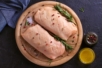 Raw uncooked poultry meat cut on wooden tray. Duck breasts with honey, rosemary and spices.
