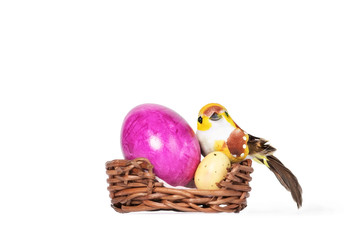 Bird and colorful eggs in Easter basket