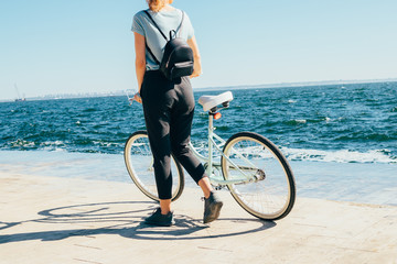 Unrecognizable young woman walking with bicycle