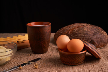 Assorted dairy products milk, cheese, eggs. rustic still life on table