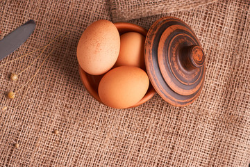Eggs with bread and kitchen utensils on vintage wooden background. Tasty food