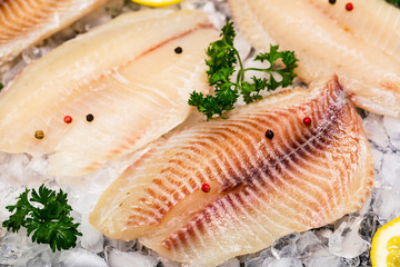 Whitefish Tilapia Fish Raw Fillet on Ice. Selective focus.