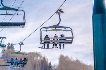 Skiers on ski lifts against sky in Park City Utah