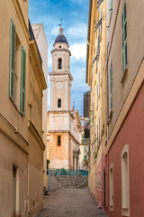 Fototapeta na wymiar Menton, typical old street, with the saint michel archange church in background