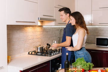 Couple cooking together in the kitchen at home