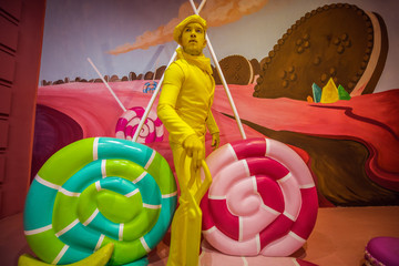 Stylized fantasy actor in scenic make-up and bright colored background.