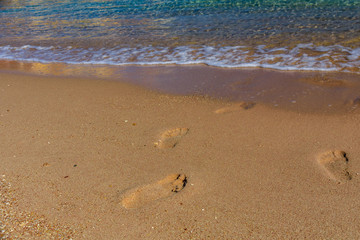 Human footprints on the sandy beach. Summer vacation concept