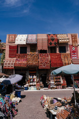 handgefertigter Teppich, der an einer Wand in Marrakesch, Marokko, hängt © SmallWorldProduction