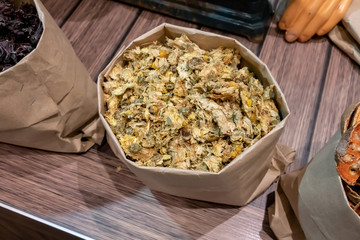 Artificial dried chrysanthemum in craft paper sack on wooden background.