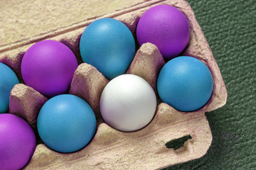 Colorful eggs in a cardboard box