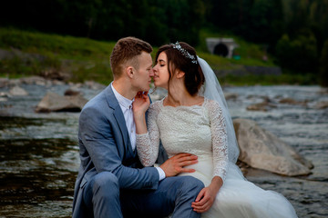 Happy newlyweds standing and smiling on the river . Honeymooners, photo for Valentine's Day