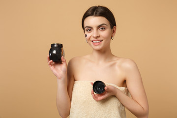 Close up brunette half naked woman 20s with perfect skin, nude make up black mask isolated on beige...
