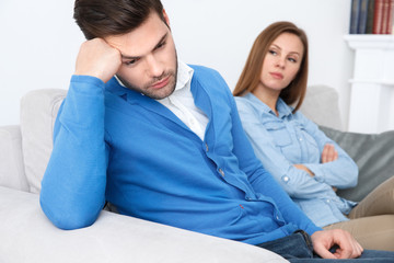 Young couple waiting for psychology session family problems guy looking down concerned