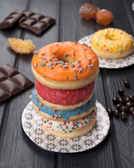 colorful glazed donuts on black wooden table