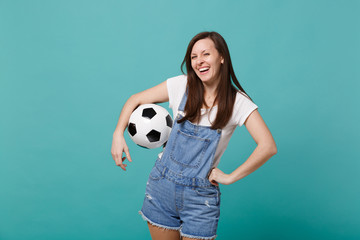 Laughing young girl football fan cheer up support favorite team with soccer ball isolated on blue...