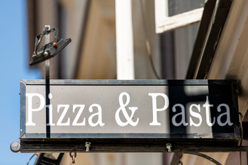 Italian restaurant pizzeria sign closeup outside with text for pizza and pasta letters on street...