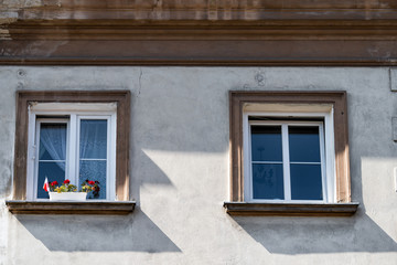 Warsaw, Poland old or new town with historic street town architecture and two windows closeup pattern flower pot and Polish flag
