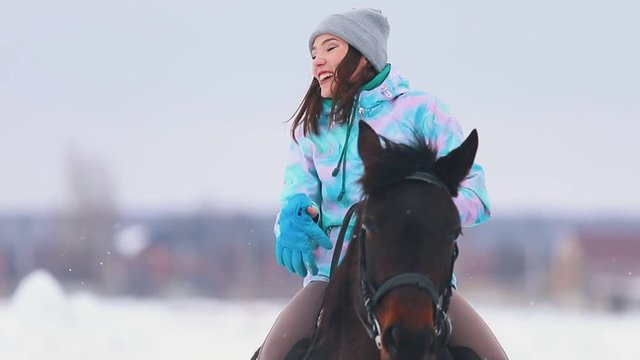 An excited young woman on a horseback talking to her friend