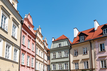 Fototapeta na wymiar Warsaw, Poland Old town square with historic street town architecture and windows multicolored pattern of pink and yellow vintage color buildings