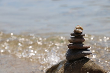 Stones in form of turret on the beach near the watter. Concept of balance and equillibrium.