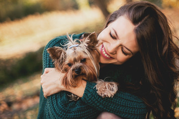 Beautiful woman hugging with dog in the park