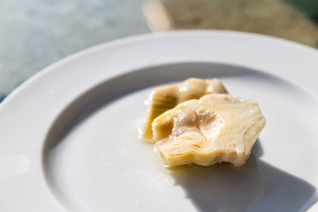 Closeup of Italy Italian artichoke appetizer on plate in olive oil marinated heart