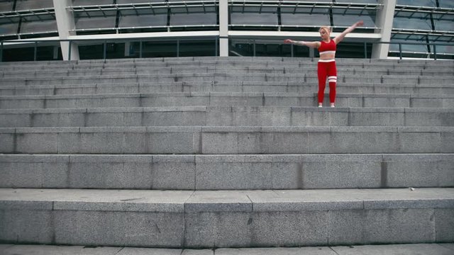 Plus size mixed race blond girl wearing red sportswear making gymnastics.