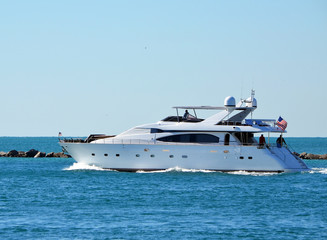 Fototapeta na wymiar White motor yacht exiting Government Cut off Miami Beach,Florida