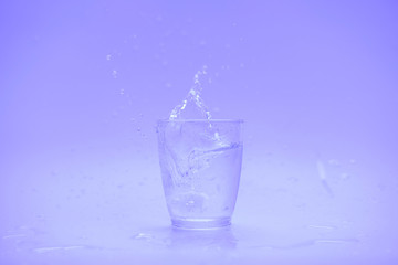 Glass of water with splash isolated on white background
