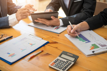 Group of business people working with laptop and tablat and paper graph in the office room. Accounting concept.
