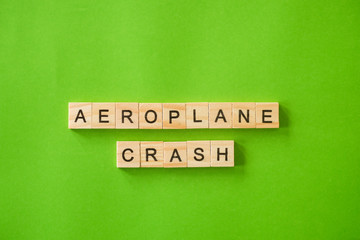 The word AEROPLANE CRASH shot flat lay on a green isolated background